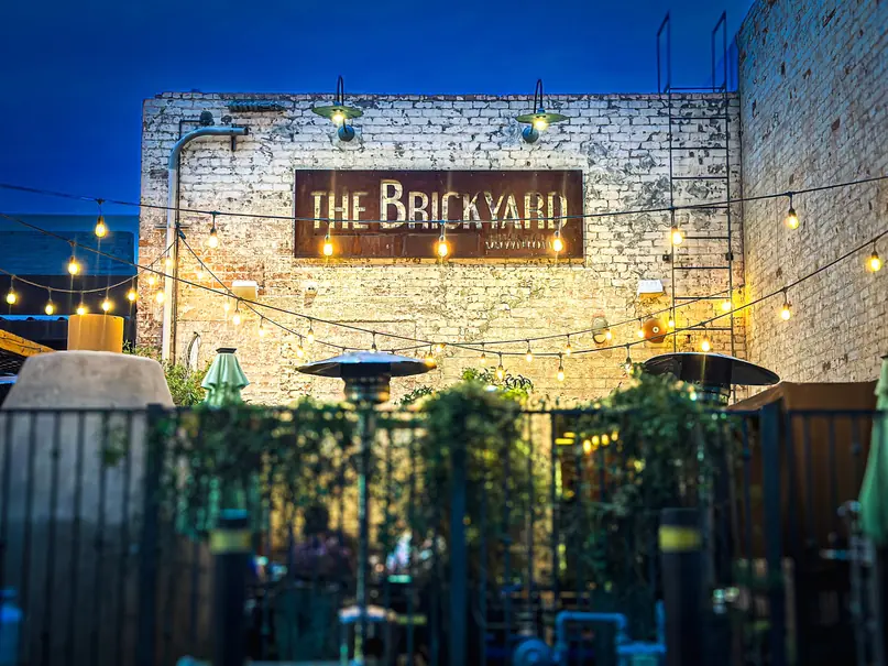 The Brickyard back patio with bistro lighting at night